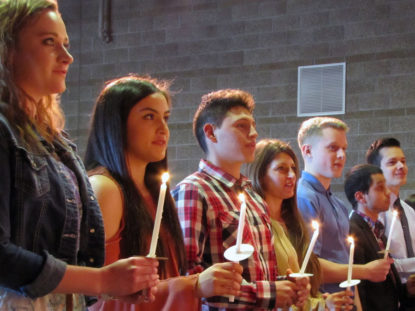 photo: Phi Theta Kappa Honor Society students hold candles during a ceremony