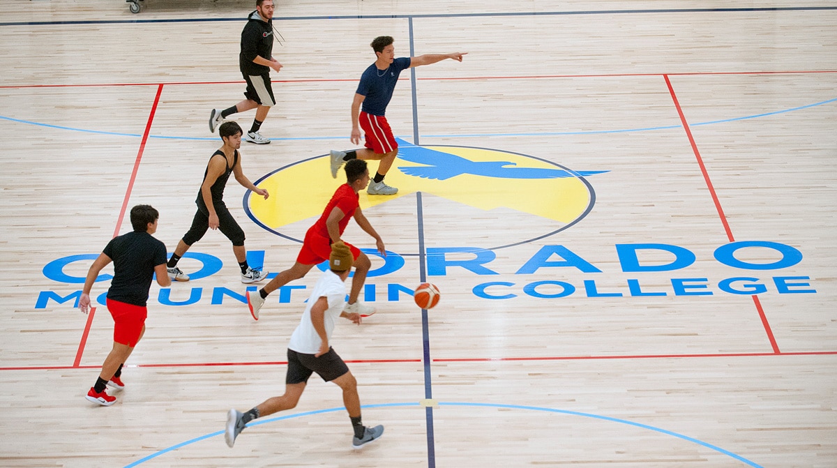 Students and community members play basketball on the two-court floor of the CMC Spring Valley Outdoor Leadership Center & Field House.