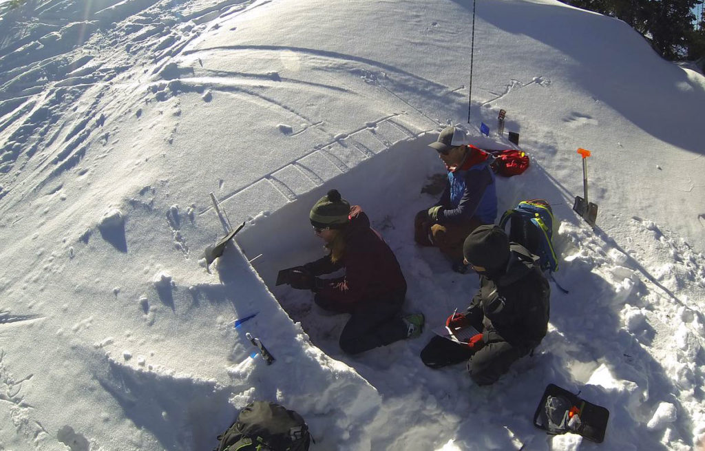 CMC instructor and students test avalanche conditions using a snow pit.