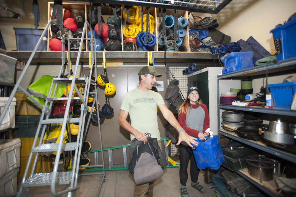 CMC Outdoor Education instructor and student get gear in the equipment garage.