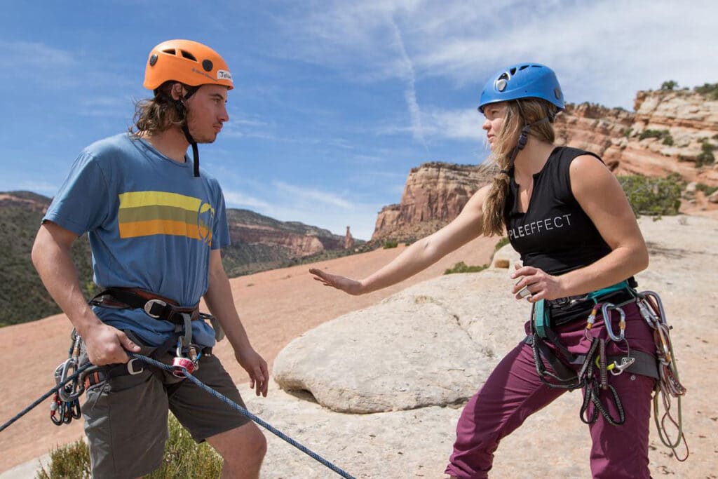 CMC Outdoor Education rock climbing instructor setting up a rappell with a student.