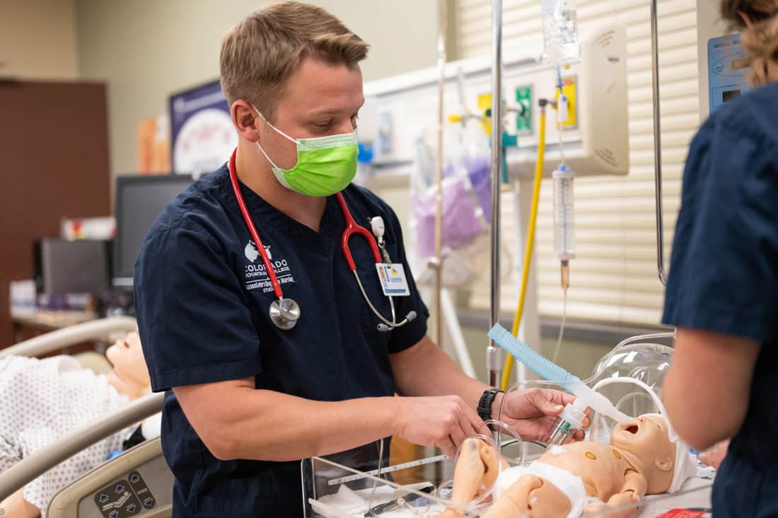 CMC nursing student Travis Samila cares for a 2-month-old infant mannequin in a CMC nursing simulation lab who is having trouble breathing. "Sim labs" give students the ability to assess patients and practice medical techniques. Photo by Ben Suddendorf