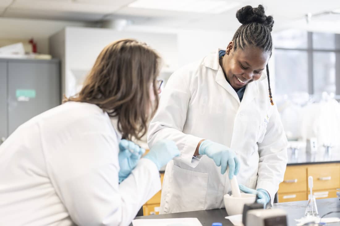 A CMC student performs an experiment in a lab.